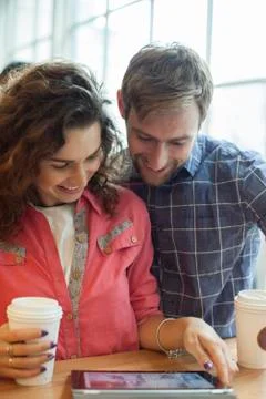 Couple using digital tablet in coffee shop Stock Photos