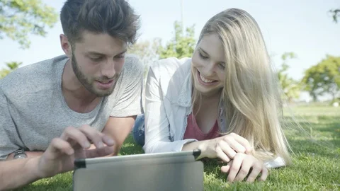 Couple using digital tablet in park Stock Footage 106315441