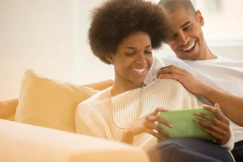 Couple using digital tablet on sofa Stock Photos