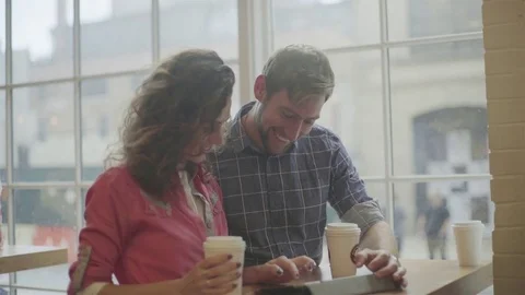 Couple using digital tablet together in coffee shop Stock Footage 75187378