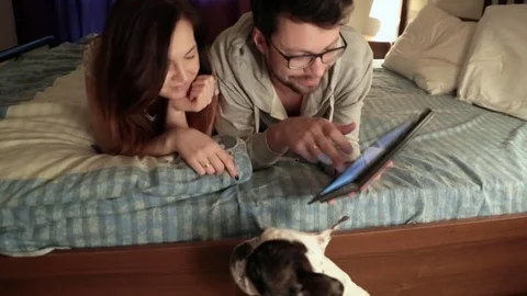 Couple using digital tablet touchscreen ipad watching movies Stock Footage 73452091