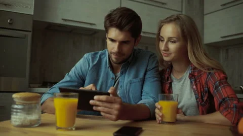 Couple using a digital tablet while having breakfast at home Stock Footage 68732463