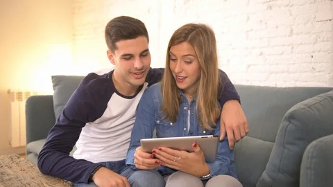 COUPLE using internet tablet pad happy together Stock Footage 87333091
