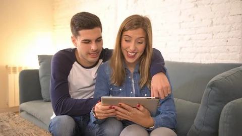 COUPLE using internet tablet pad happy together Stock Footage 87333289