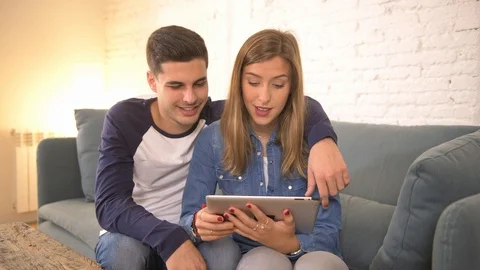 COUPLE using internet tablet pad happy together Stock Footage 87333445