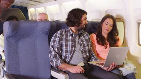 Couple using laptop on airplane Stock Footage 67344743