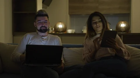 Couple using laptop and tablet Stock Footage 100001546
