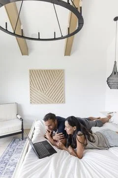 Couple using laptop on bed Foto stock