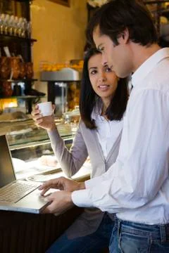 Couple using laptop computer in cafe Stock Photos