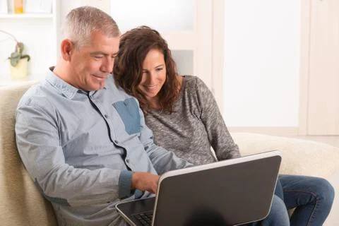Couple using laptop at home Stock Photos