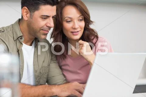 Couple using laptop in the kitchen Stock-Fotos