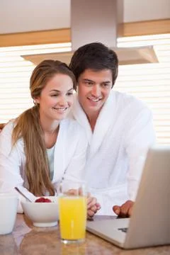 Couple using laptop over breakfast Fotos Stock