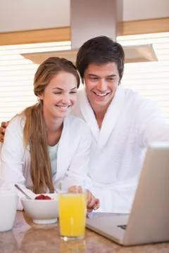 Couple using laptop over breakfast Fotos Stock