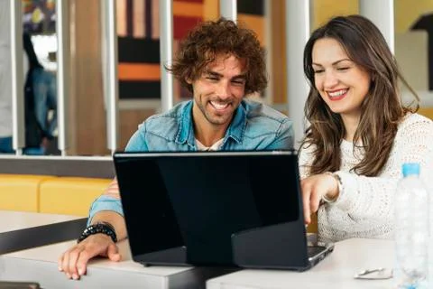 Couple using the laptop in the restaurant. Stock Photos