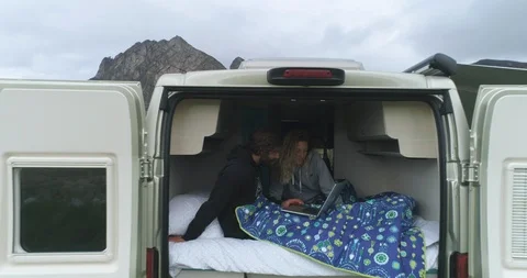 Couple using laptop while relaxing in campervan Stock Footage 85962405