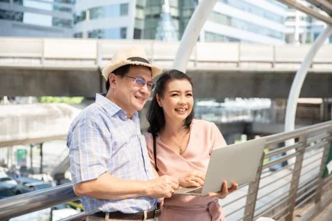 Couple Using Laptop While Standing On Bridge In City Stock Photos
