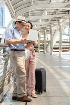 Couple Using Laptop While Standing On Bridge In City Stock Photos