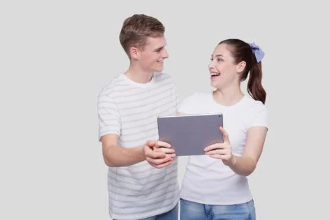 Couple Using Looking at Each Other Tablet Isolated. Couple Shopping Online. Stock Photos