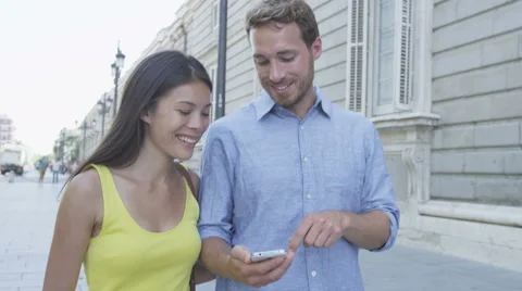 Couple using mobile cell smart phone in city Stock Footage 46395688