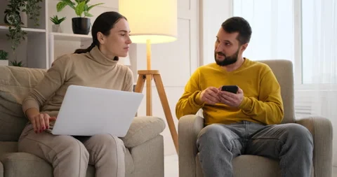 Couple using mobile phone and laptop at home Stock Footage 145218695