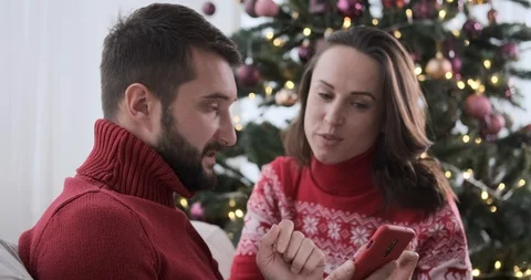 Couple using mobile phone during Christmas at home Stock Footage 129425109