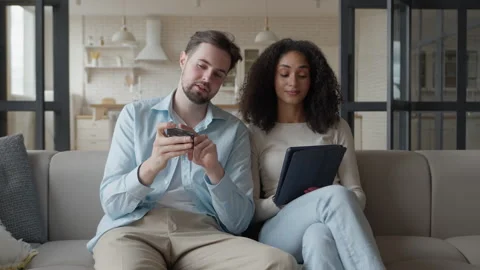 Couple Using Smartphone And Tablet Together While Relaxing On Sofa Stock Footage 344696470