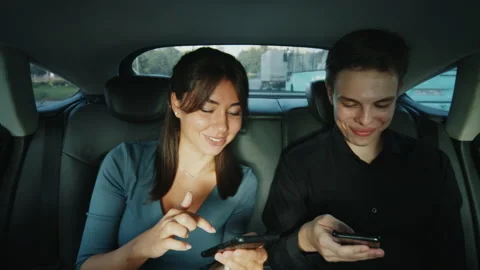 A couple using smartphone browsing social media communication in taxi backseat. Stock-Footage 218283017