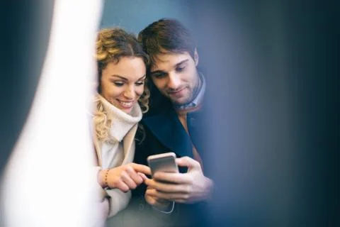 Couple using smartphone inside train Stock Photos