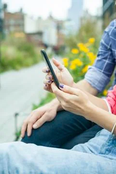 Couple using smartphone outdoors, cropped Stock Photos