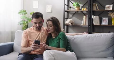 Couple using smartphone, shopping online, ordering delivery, checking social Stock Footage 264404466