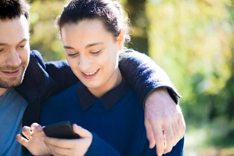 Couple using smartphone in woods Stock Photos