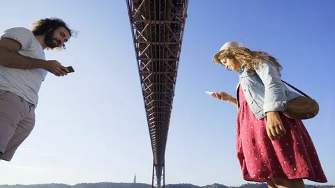 Couple using smartphones under bridge Stock Footage 105204291