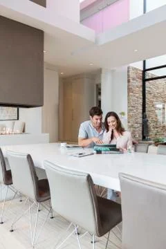 Couple using tablet pc in dining room Stock Photos