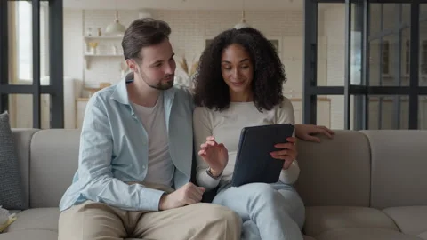 Couple Using Tablet Together While Relaxing On Sofa At Home Stock Footage 344697108