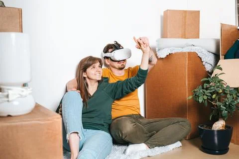 Couple Using VR During Apartment Move Besides Cardboard Boxes Stock Photos