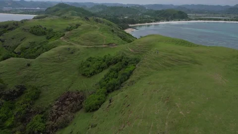 Couple Ventures Down Lush Slope To Peaceful Oceanfront With Rocks And Waves 스톡 동영상 330372075