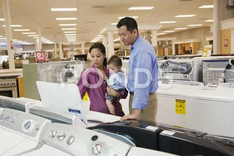Couple viewing washing machines in appliance showroom Stock Photos