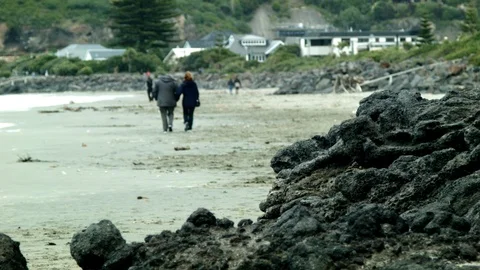 A couple walk along the beach Stock Footage 89702656
