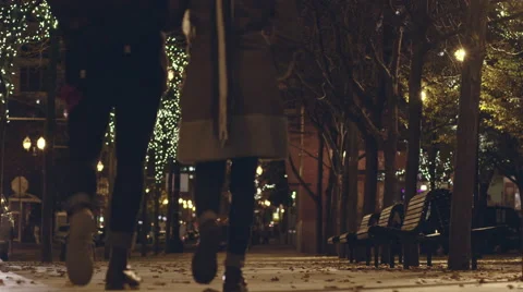 Couple walk to a bench and sit at night. Vídeos de archivo 60255508