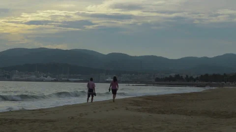 Couple walk down beach in Palma Stock Footage 32258878
