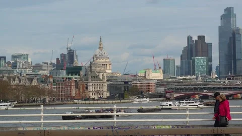 Couple walking across Waterloo Bridge with St Paul’s Cathedral and London Vídeo Stock 337568186
