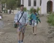 Couple walking along beach SD Footage