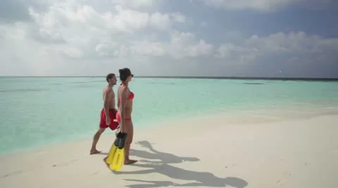 Couple walking along beach Stock Footage 10788267