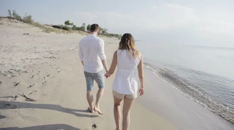 Couple walking along beach Stock Footage 61799137