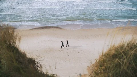 Couple walking along the beach Stock Footage 83456275