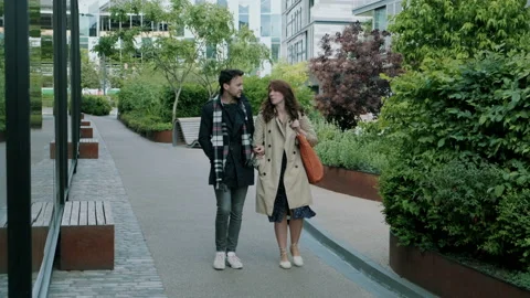 Couple walking along empty street having a conversation Stock Footage 130596809
