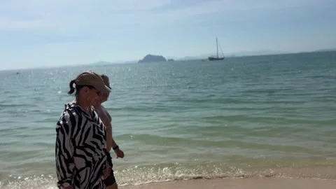 Couple Walking Along Koh Yao Yai Beach Thailand with Boat in Background on Stock Footage 337928035