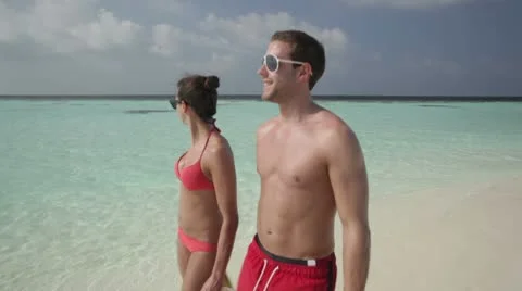 Couple walking along lagoon Stock Footage 10788254