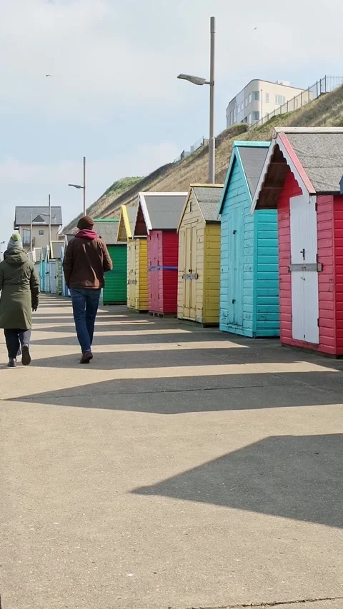 Couple walking along Sherignham seafront Video stock 305930458
