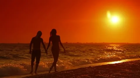 Couple Walking Along Summer Beach at Sunset Stock Footage
